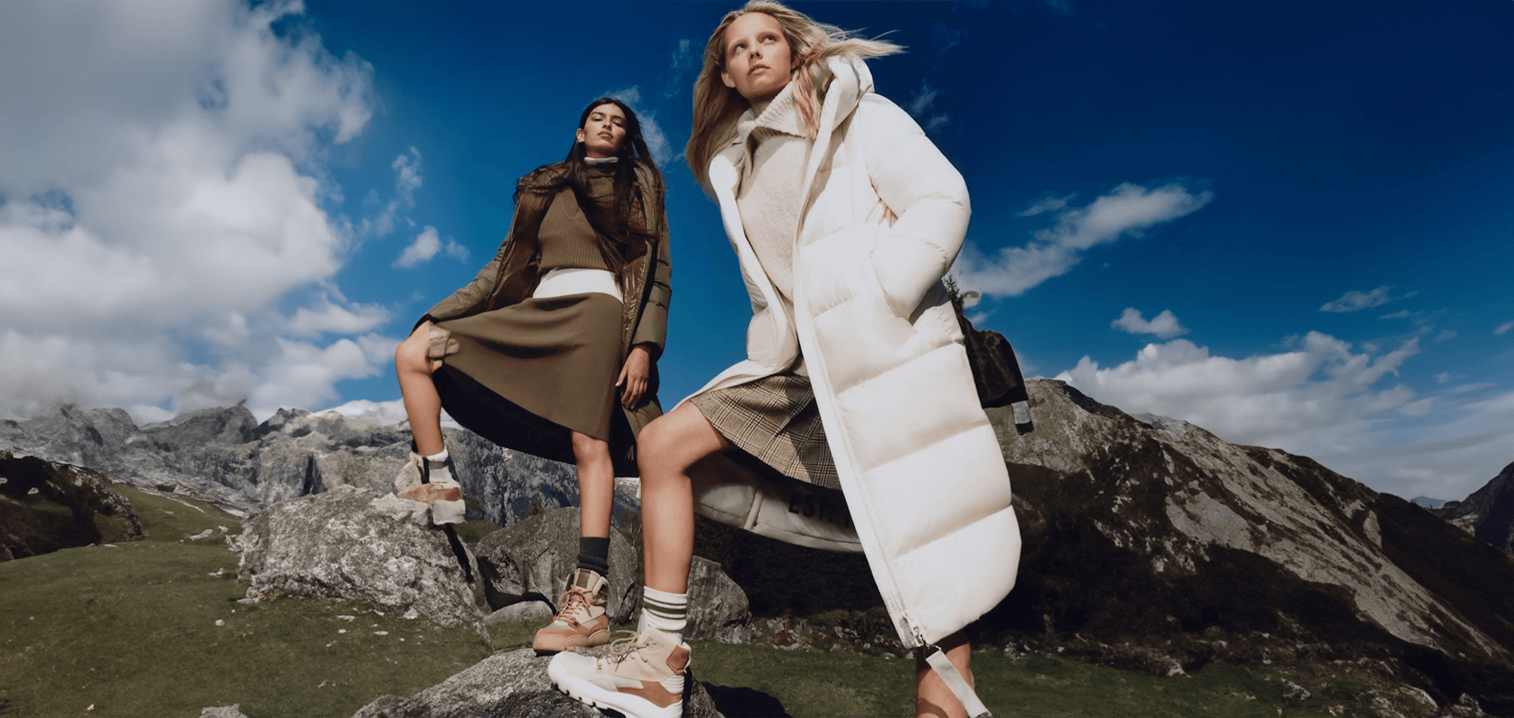 Zwei Frauen mit Jacken, Pullovern und Rücken auf einem Berg, für die Marc O'Polo Success Story